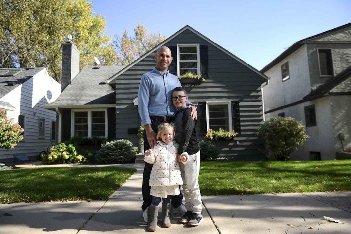 Ian Harrison stood for a portrait outside his Southwest Minneapolis home with his two children Stellan, 8 and Phoebe, 3.