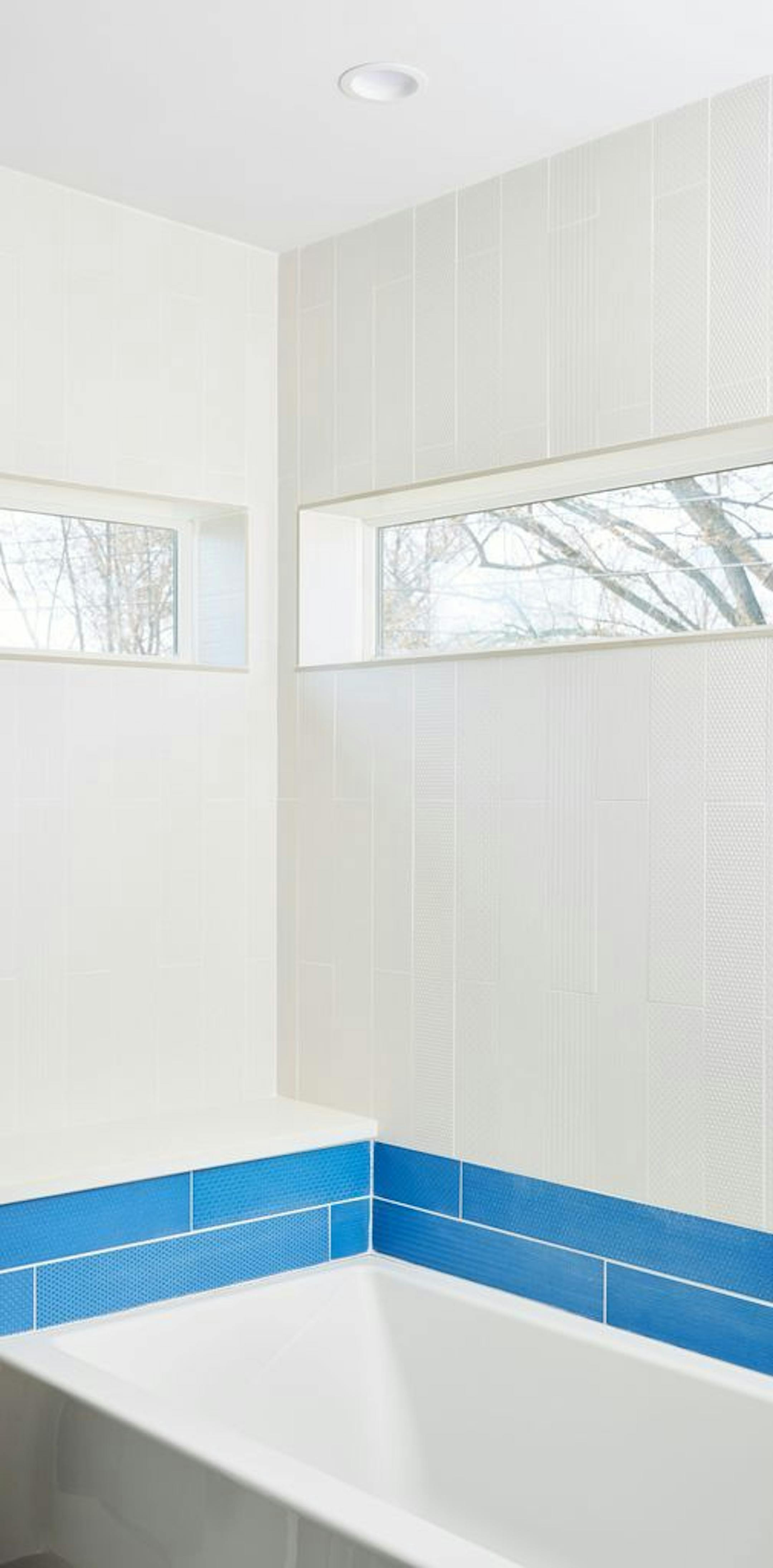 Blue tile and slot windows highlight the shower.