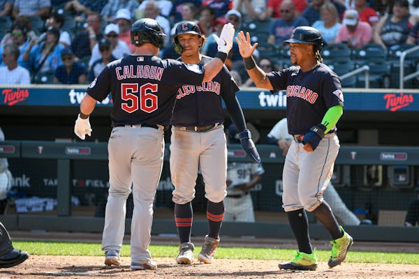 The Guardians’ Kole Calhoun celebrated with Bo Naylor, center, and José Ramírez after hitting a three-run home run in the 10th inning against the 