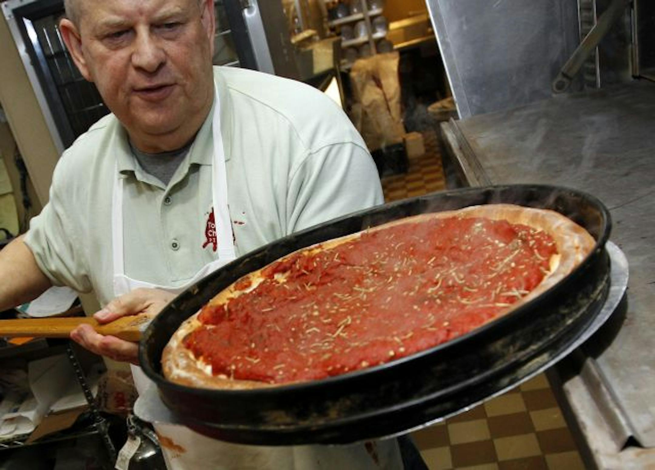 Deep dish: Tommy Chicago's Pizzeria owner Tom Magnuson at the oven.