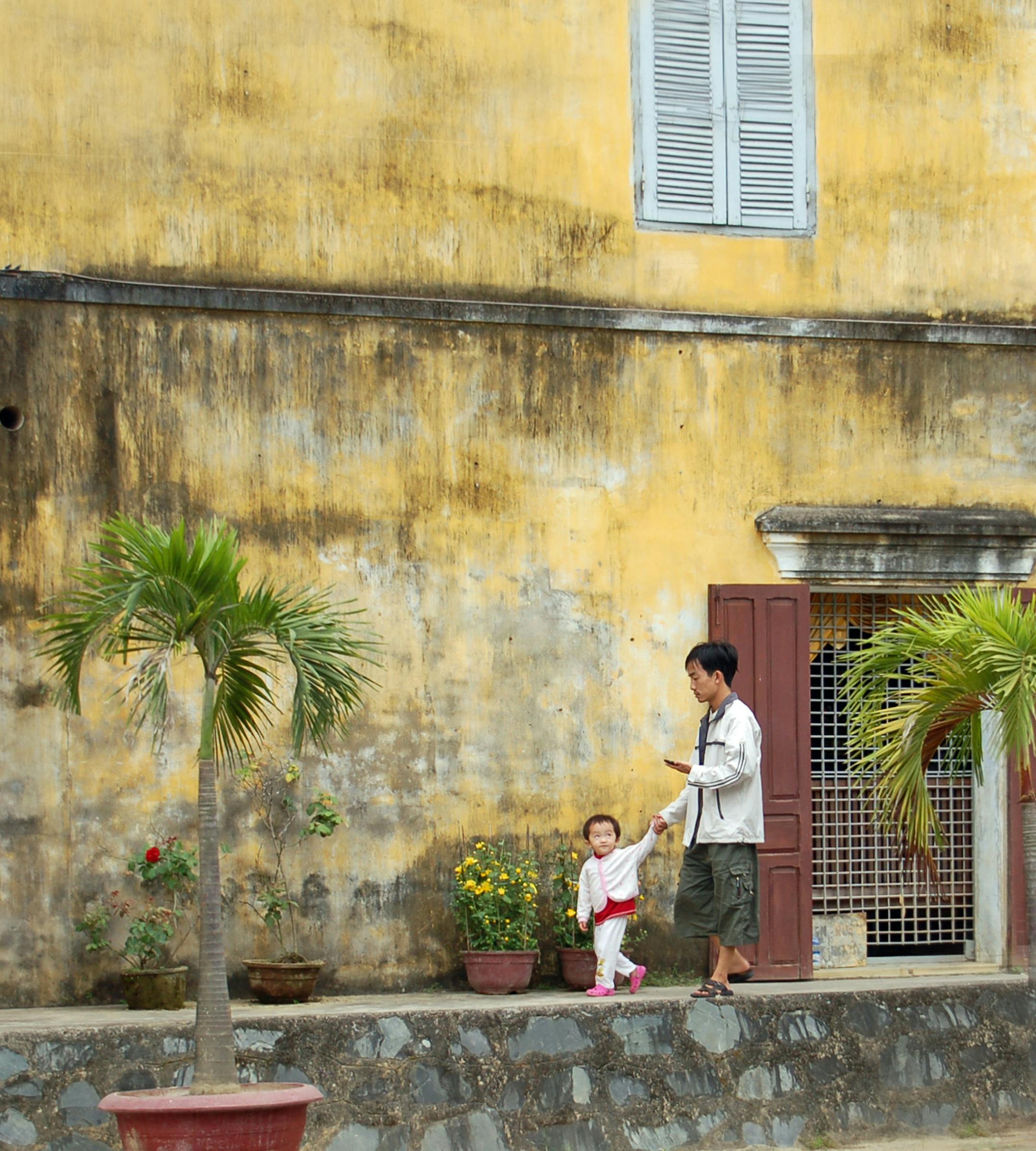 I visited Vietnam before the pandemic began, but this photograph taken in Hoi An's old quarter of a father and son spending family time together on a quiet walk seems like it could have been taken during the pandemic. The soft neutral colors caught my eye as well as the old, mildewed plaster wall. I love the expression of respect on the little boy's face. Situated on the banks of a river, the little town of Hoi An feels caught in a time warp. Narrow streets, huddled wooden shophouses and a corru