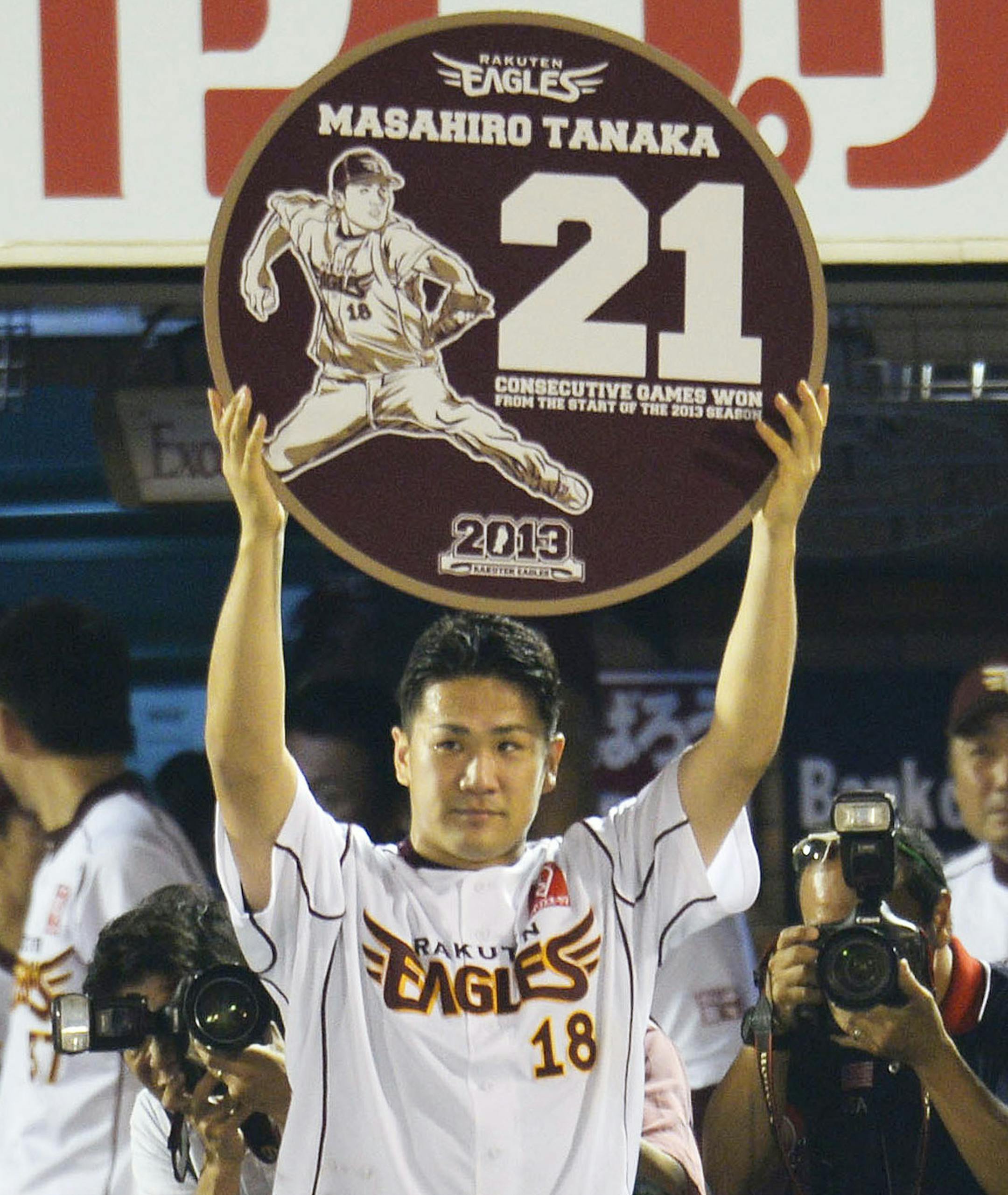 Rakuten Eagles pitcher Masahiro Tanaka raises a special plate written with 21 and his name after pitching against the Orix Buffaloes to win his 21st straight game, setting a new Japanese professional baseball record for consecutive victories in one season, at his team's home stadium in Sendai, northwestern Japan, Friday, Sept. 13, 2013. Tanaka improved to 21-0 on Friday after giving up two runs in a complete game in the Eagles' 6-2 win over the Buffaloes. The previous record of 20 was set in 195