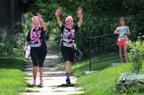 Walkers participating in the Susan G Komen 3-Day approach pit stop 3 near Brackett Recreation Center Friday, Aug. 16, 2019, in Minneapolis, MN. Here, sisters Julie Ashley, left, of Bradenton, FL, and Suzy Warren of Center City, dance and wave as they approach the pit stop. Julie is a 6 year cancer survivor. "We're rocking it," she said.