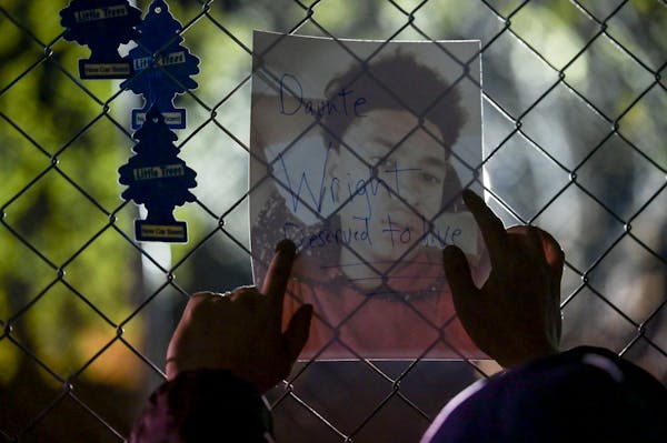 A man held a portrait of Daunte Wright against the fence during a protest outside the Brooklyn Center police station in April.