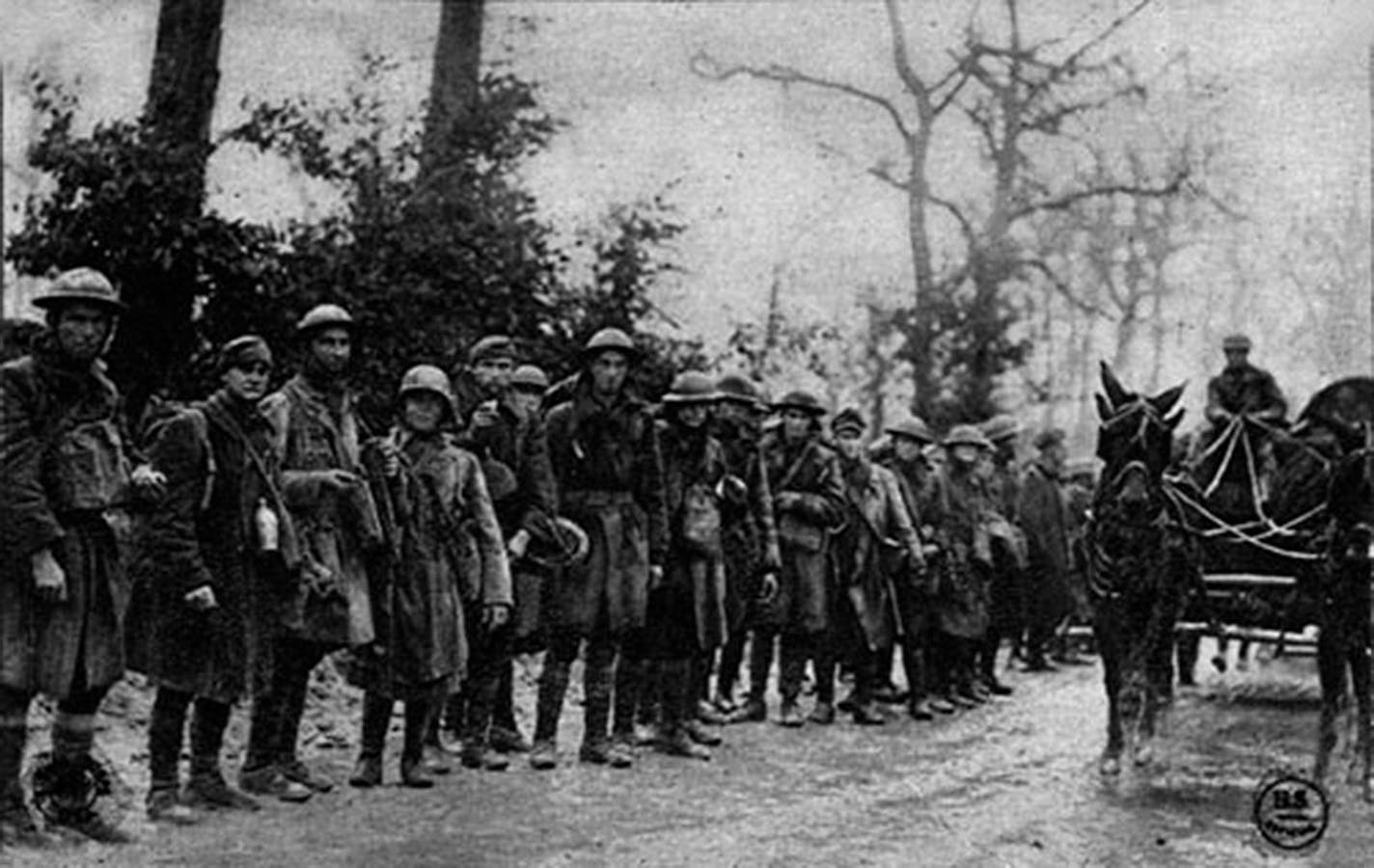 U.S. soldiers coming off the line after 20 days of action in the Meuse-Argonne Offensive. One of them is Fred McComber Jr., the author's grandfather (near the far right), facing right, with his campaign hat cocked to the back of his head.