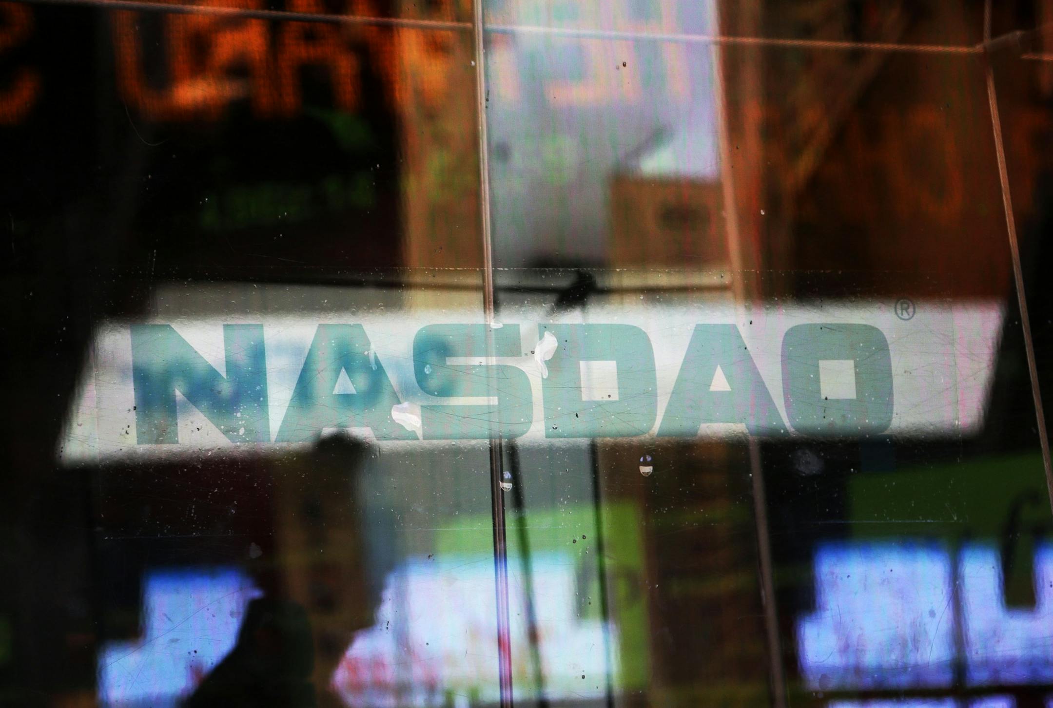 FILE - In this Thursday, Aug. 22, 2013, file photo, electronic billboards are reflected in the windows of Nasdaq in New York. The Nasdaq Composite is up 35 percent in 2013, but while other major indexes like the Dow Jones industrial average and Standard & Poorís 500 have celebrated all-time highs again and again, the Nasdaq remains 20 percent below its dot-com peak of 5,048.62. (AP Photo/Seth Wenig, File)