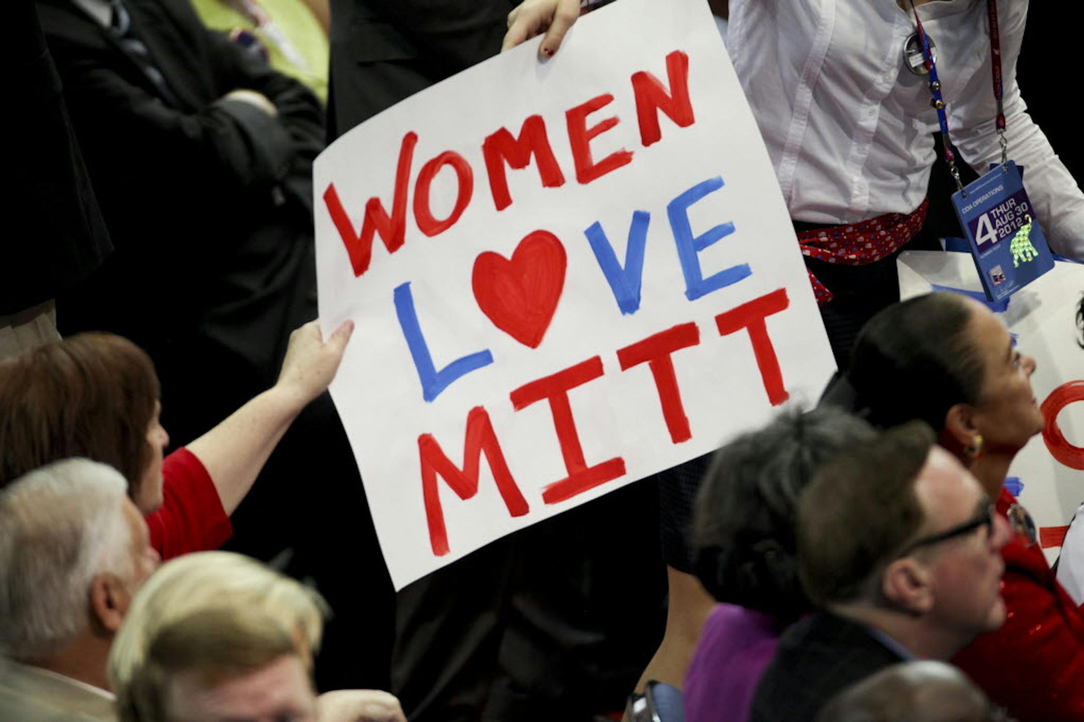 Attendees grab signs during the Republican National Convention in Tampa, Fla.