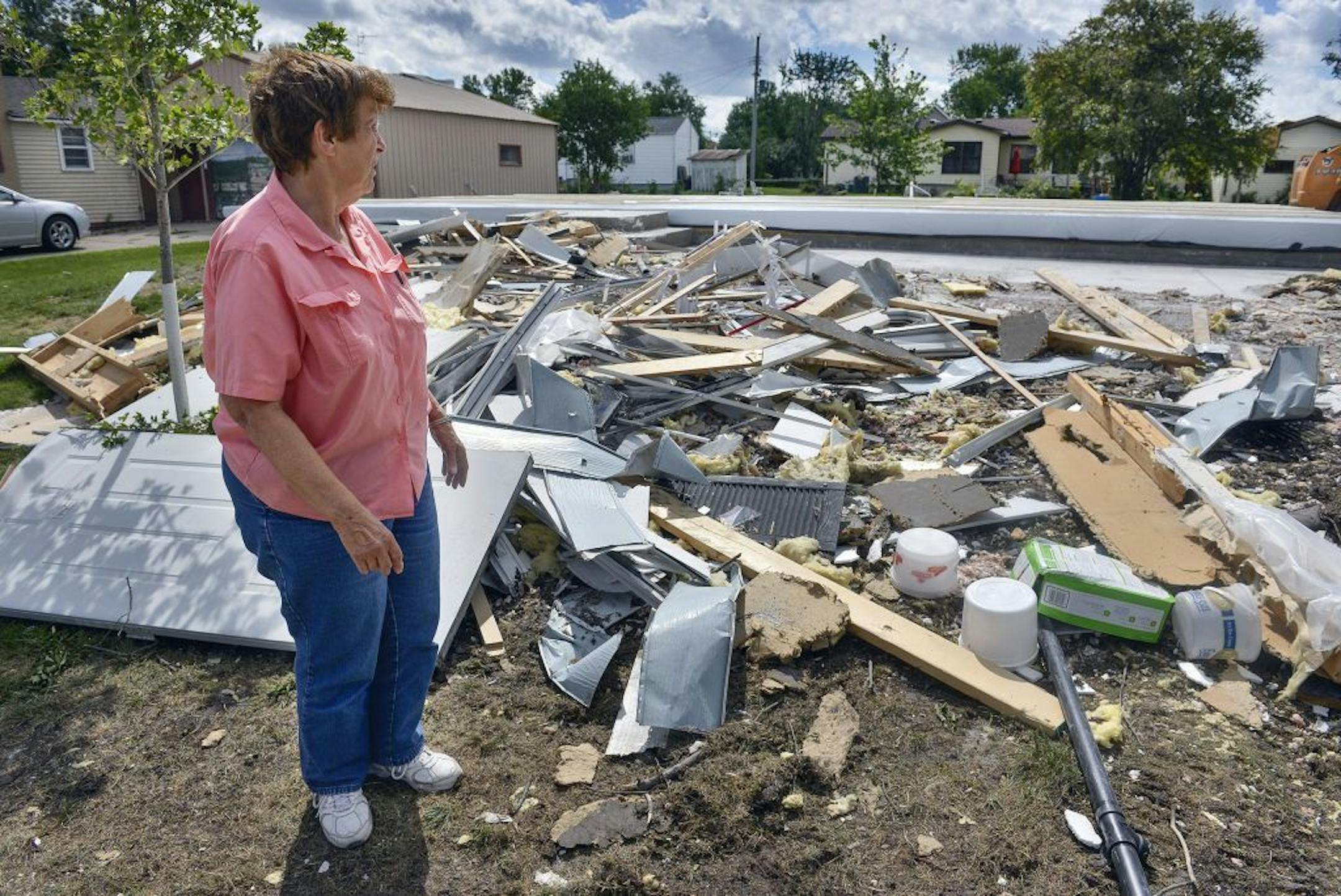 As the cleanup continues July 13, Watkins, Minn., City Councilwoman Tootz Tschumperlin surveys rubble left over from her home which was destroyed in a tornado Monday, July 11, 2016. The home was razed and the foundation covered to prepare for its replacement.