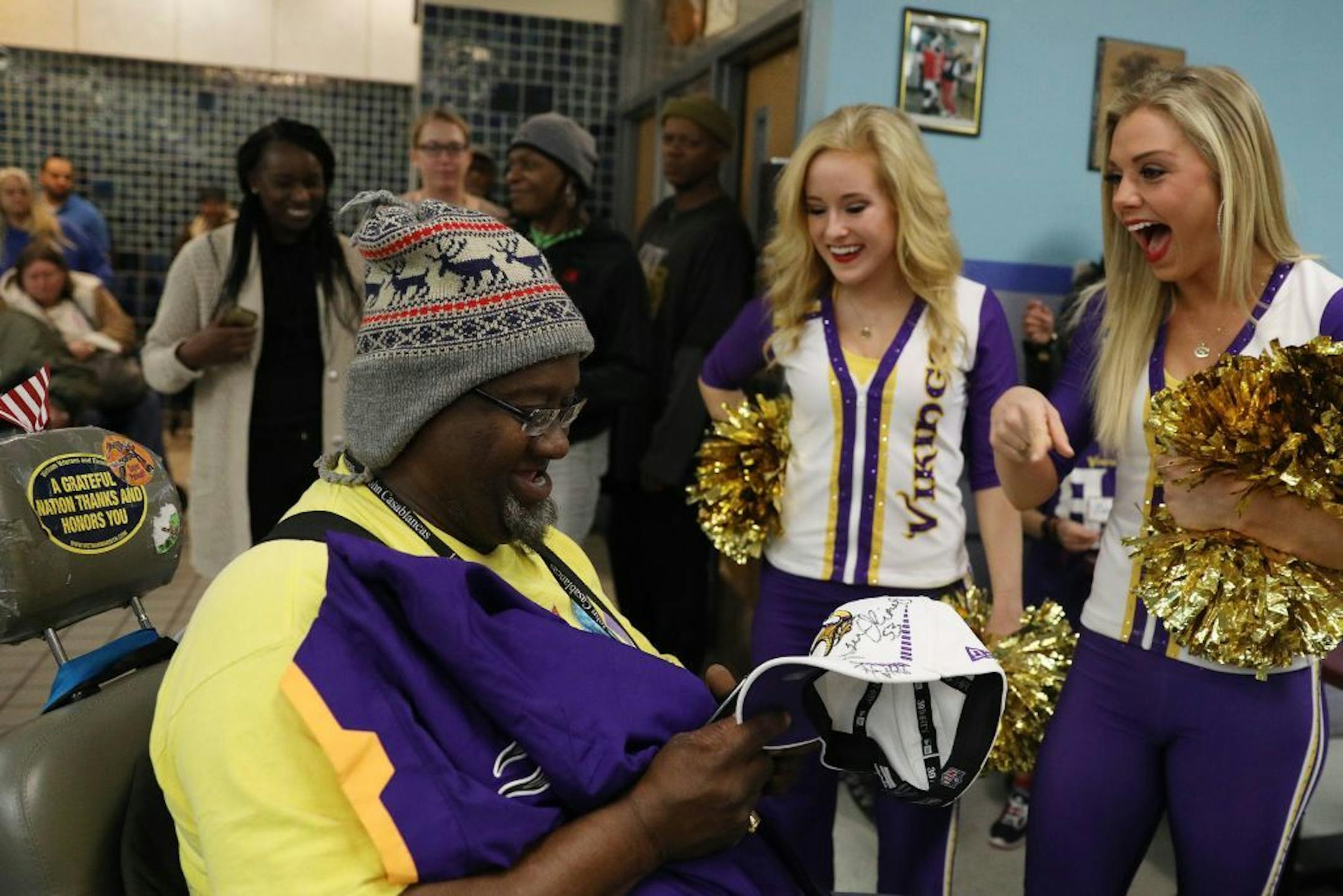 Abdul Ali smiled after being given an autographed hat and jersey by cheerleaders Gretta, left, and Hannah after his number was called during a raffle Tuesday.