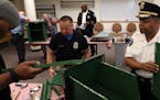 Police officers Troy Dillard, left, and Kou Vang, center, worked along with Police Chief Medaria Arradondo to build a free-standing Little Free Librar