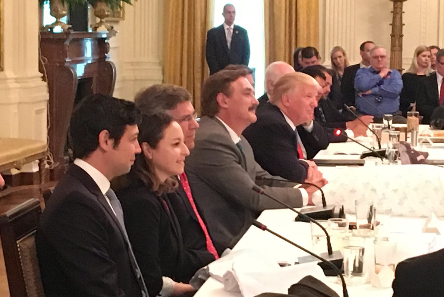 MyPillow founder Mike Lindell sits between President Trump and U.S. Rep. Erik Paulsen at a recent business roundtable at the White House. One of his signature pillows sits on the table in front of him.