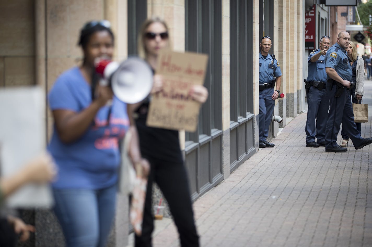 St. Paul police officers stood at a distance during a chant for prosecution for the police officer who shot Philando Castile during a protest organized by the Twin cities Coalition for Justice for Jamar outside the Ramsey County Attorney's office in downtown St. Paul, Minn., on Friday, July 15, 2016. ] RENEE JONES SCHNEIDER &#x2022; reneejones@startribune.com