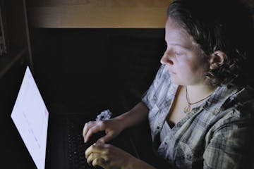 FILE - In this Monday, Sept. 26, 2011 file photo, 22-year-old Catherine Devine reads instant messages on her laptop screen at her home in Kings Park, 