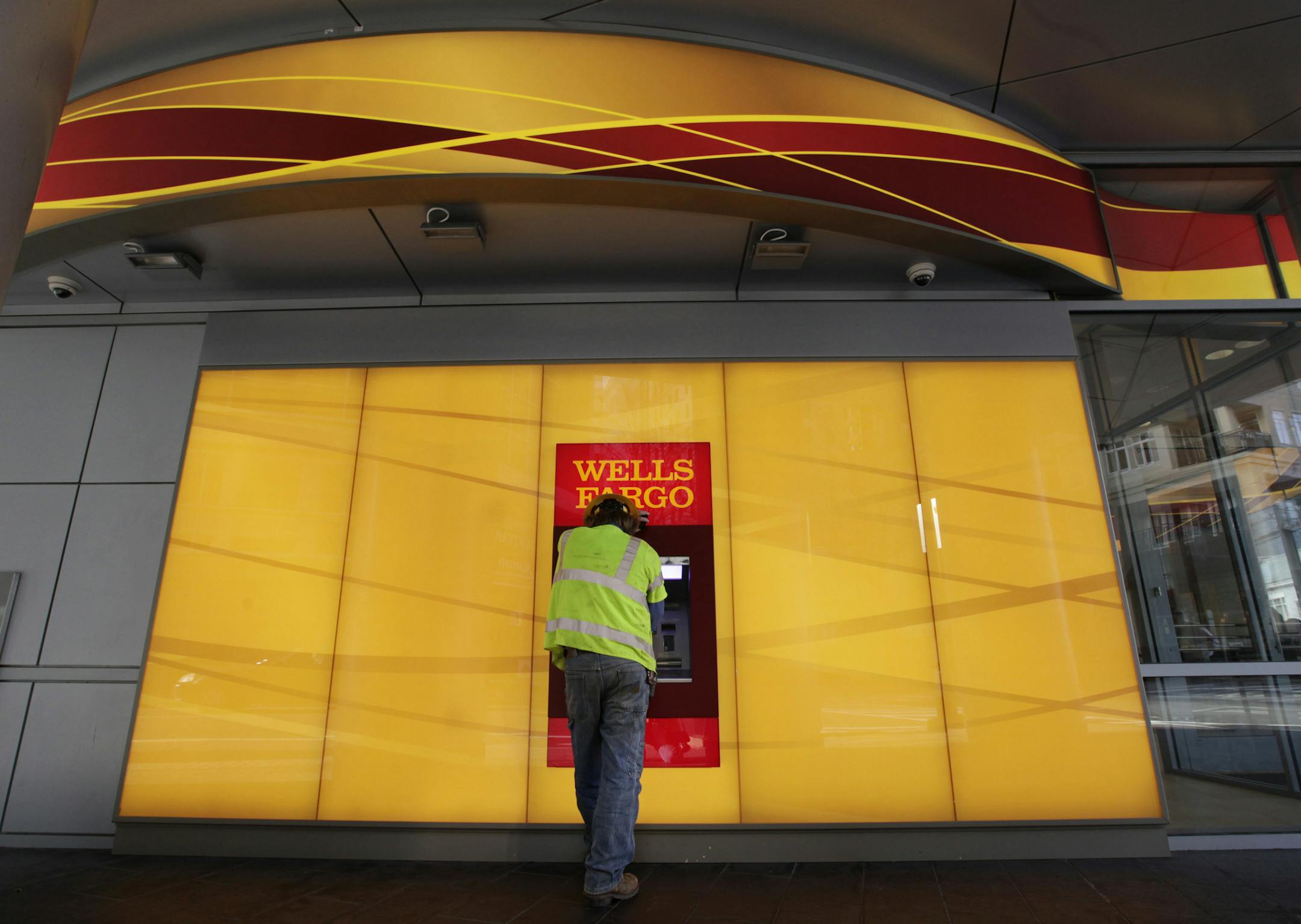 FILE - In this Tuesday, Jan. 17, 2012, file photo, a customer uses an ATM outside a Wells Fargo branch in Charlotte, N.C. Newly appointed Wells Fargo CEO Tim Sloan told employees Tuesday, Oct. 25, 2016, that he is "sorry for the pain" that the bank's employees have suffered as a result of the company's sales practices scandal. (AP Photo/Chuck Burton, File)