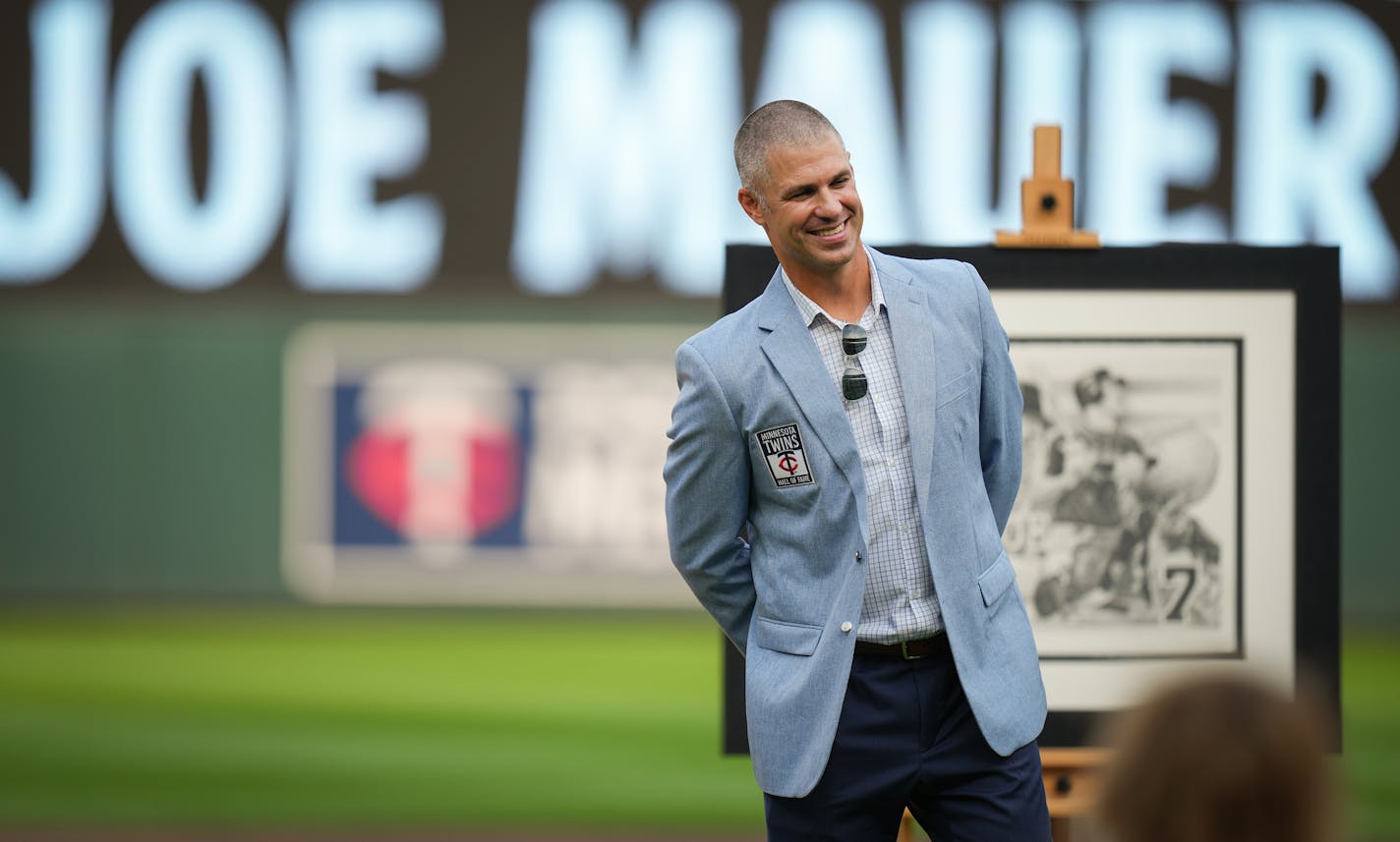 Joe Mauer stands in front of an original artwork given to him during his induction into the Twins Hall of Fame on Saturday night at Target Field.