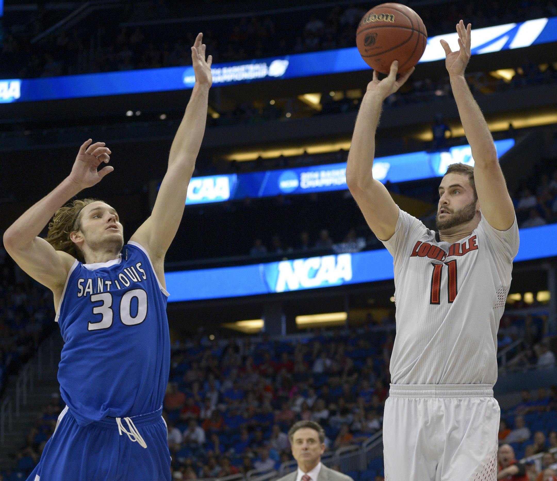 Louisville forward Luke Hancock (11) shoots a 3-point shot as Saint Louis forward Jake Barnett (30) defends during the second half in a third-round game in the NCAA college basketball tournament Saturday, March 22, 2014, in Orlando, Fla. Louisville won 66-51. (AP Photo/Phelan M. Ebenhack)