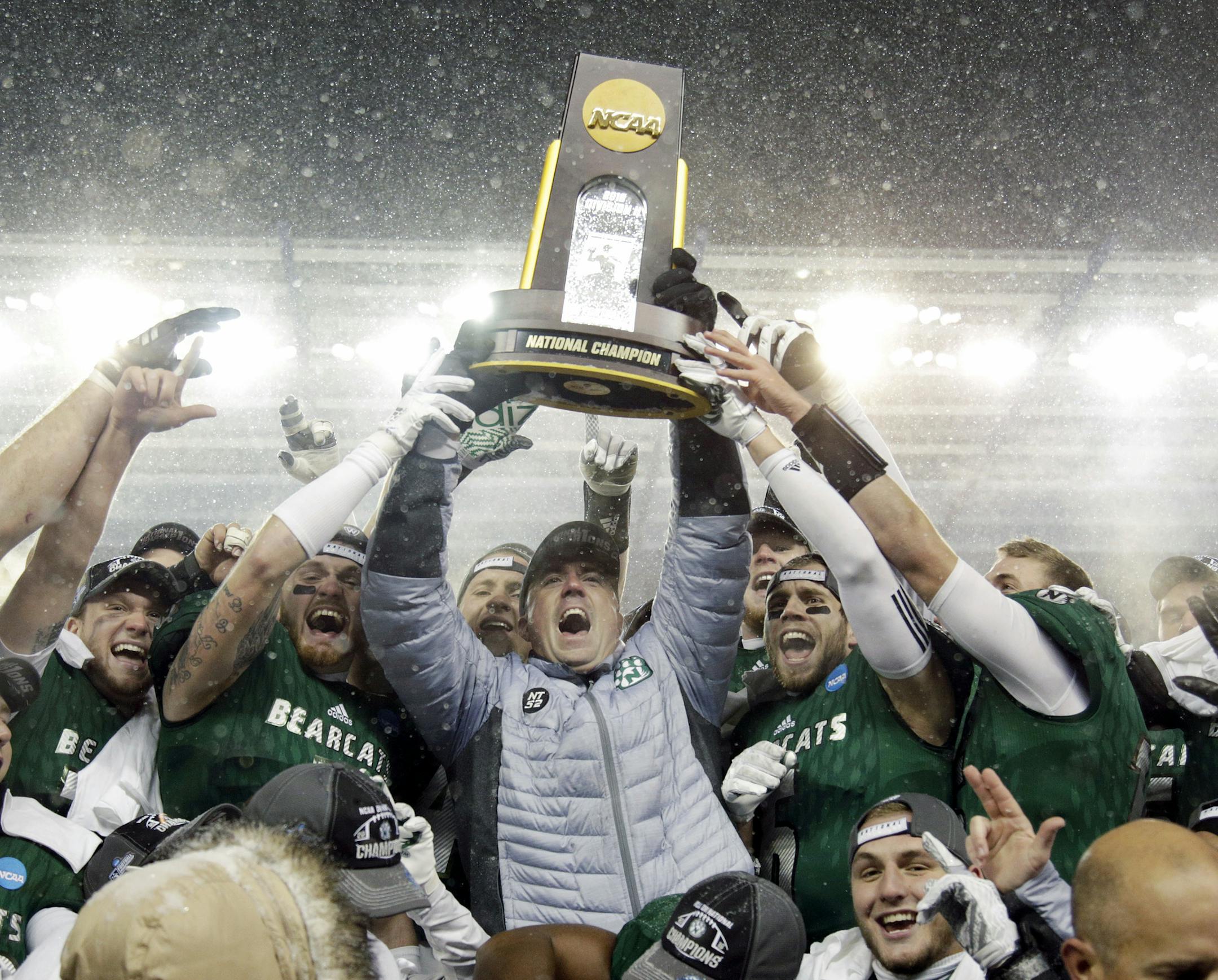 Northwest Missouri State head coach Adam Dorrel, center, holds up the championship trophy after an NCAA Division II championship football game against North Alabama, Saturday, Dec. 17, 2016, in Kansas City, Kan. Northwest Missouri State won 29-3. (AP Photo/Colin E. Braley)