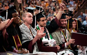 William Chancellor raises his fist as a student on stage displays a pro-Palestine banner at the University of Minnesota’s College of Liberal Arts gr