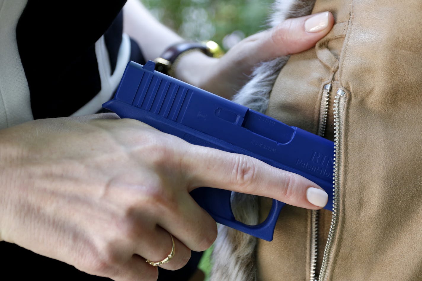 FILE - In this Aug. 29, 2016 file photo, Marilyn Smolenski uses a mock gun to demonstrate how to pull a handgun out of concealed carry clothing she designs at her home in Park Ridge, Ill. In December 2017, the GOP-controlled U.S. House of Representatives voted largely along party lines last month to pass the Concealed Carry Reciprocity Act, which would prevent states from enforcing their own handgun permit laws against out-of-state visitors. (AP Photo/Tae-Gyun Kim)