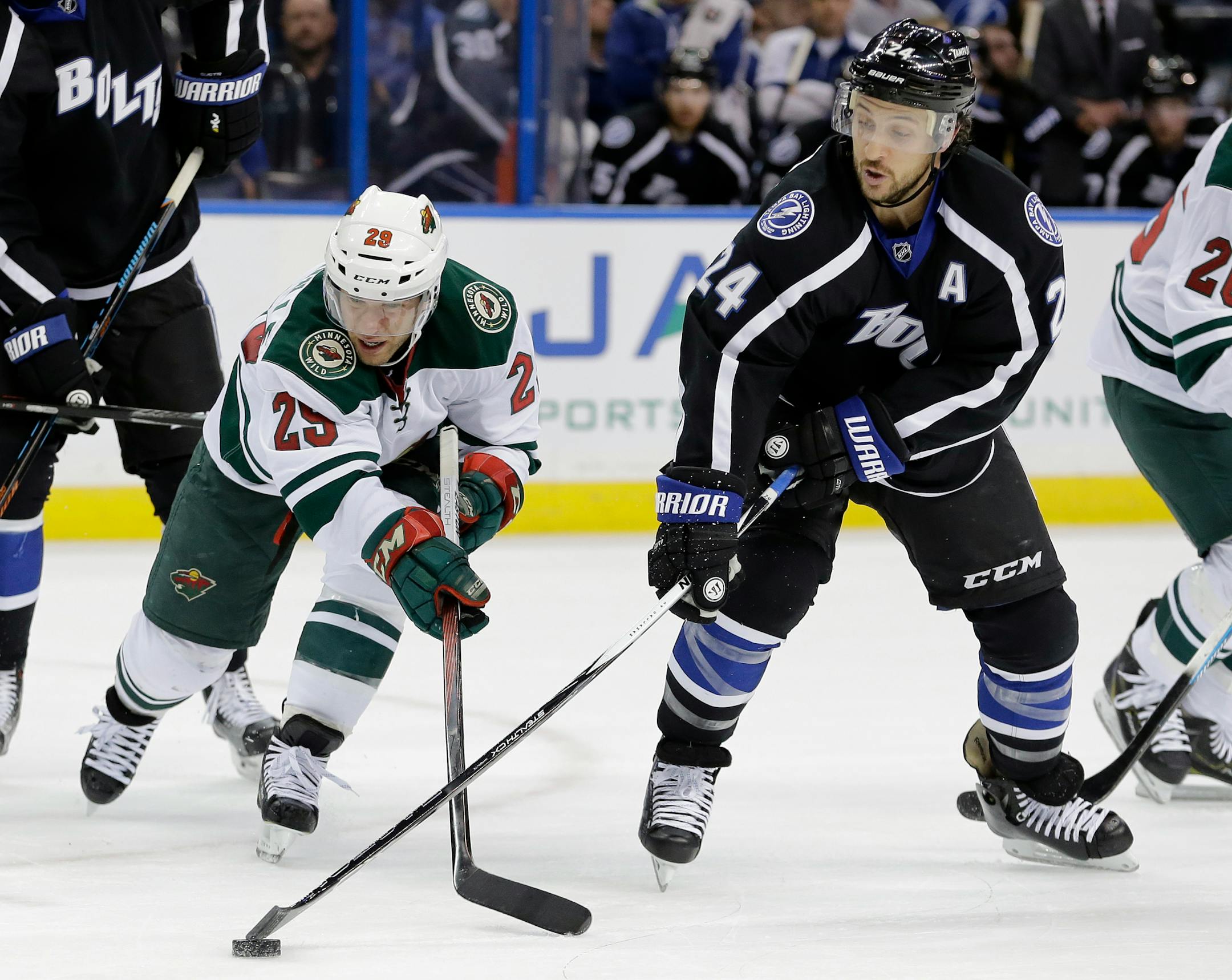 Tampa Bay Lightning right wing Ryan Callahan (24) steals a pass intended for Minnesota Wild right wing Jason Pominville (29) during the first period of an NHL hockey game Saturday, Jan. 2, 2016, in Tampa, Fla. (AP Photo/Chris O'Meara)