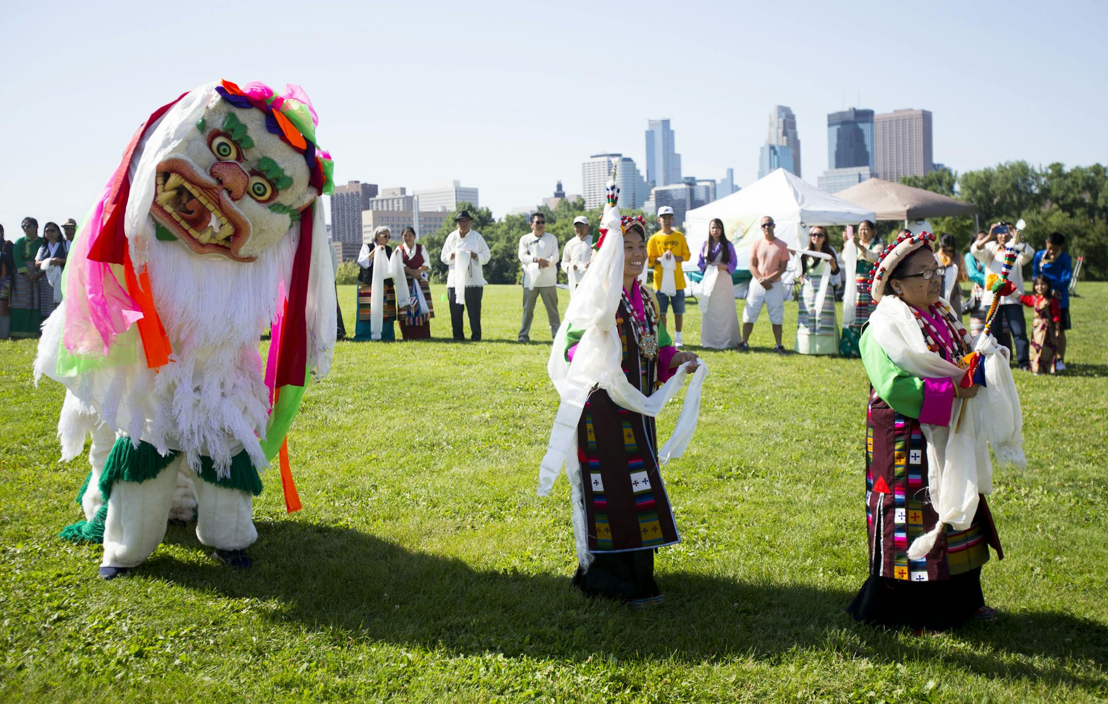 A pair of lion dancers performs in the procession behind other Tibetan dancers as community members look on. ] ALEX KORMANN • alex.kormann@startribune.com July 6, 2018 marked the 83rd birthday of the 14th Dalai Lama, the spiritual leader of Tibetan Buddhism. On July 7th, Tibetan communities from around the metro area came together at Boom Island Park to celebrate his birthday with traditional dances and prayers. Performers dressed in traditional garments and performed in a procession befo