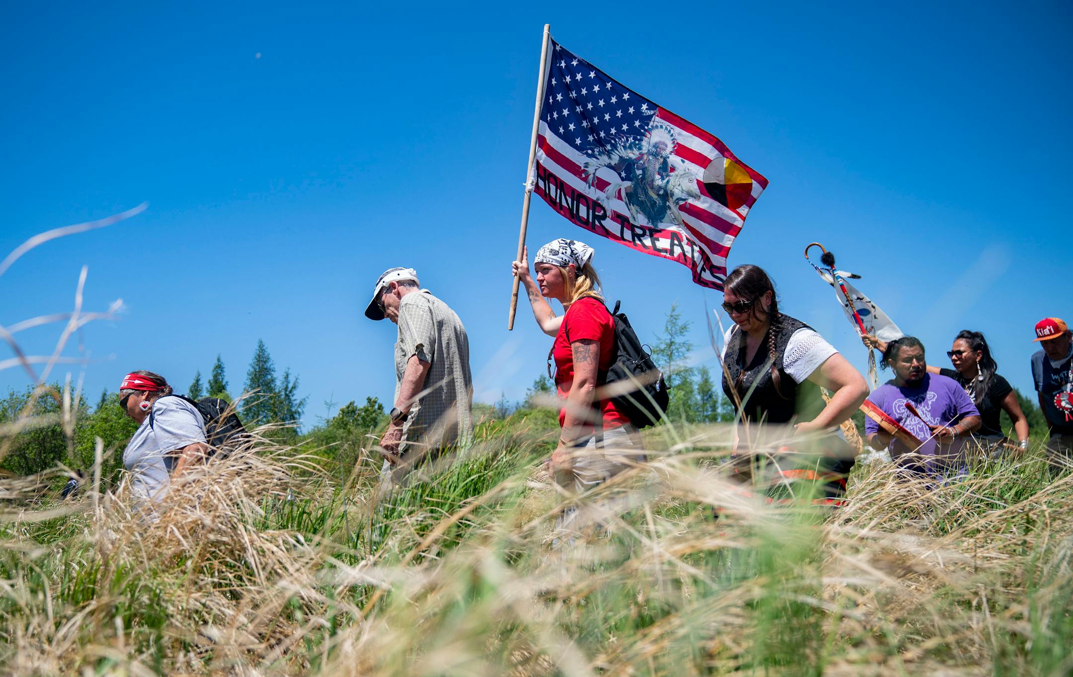 Indigenous leaders and water protectors marched through swamp land to the boardwalk leading to an Enbridge pipeline construction site on Monday.