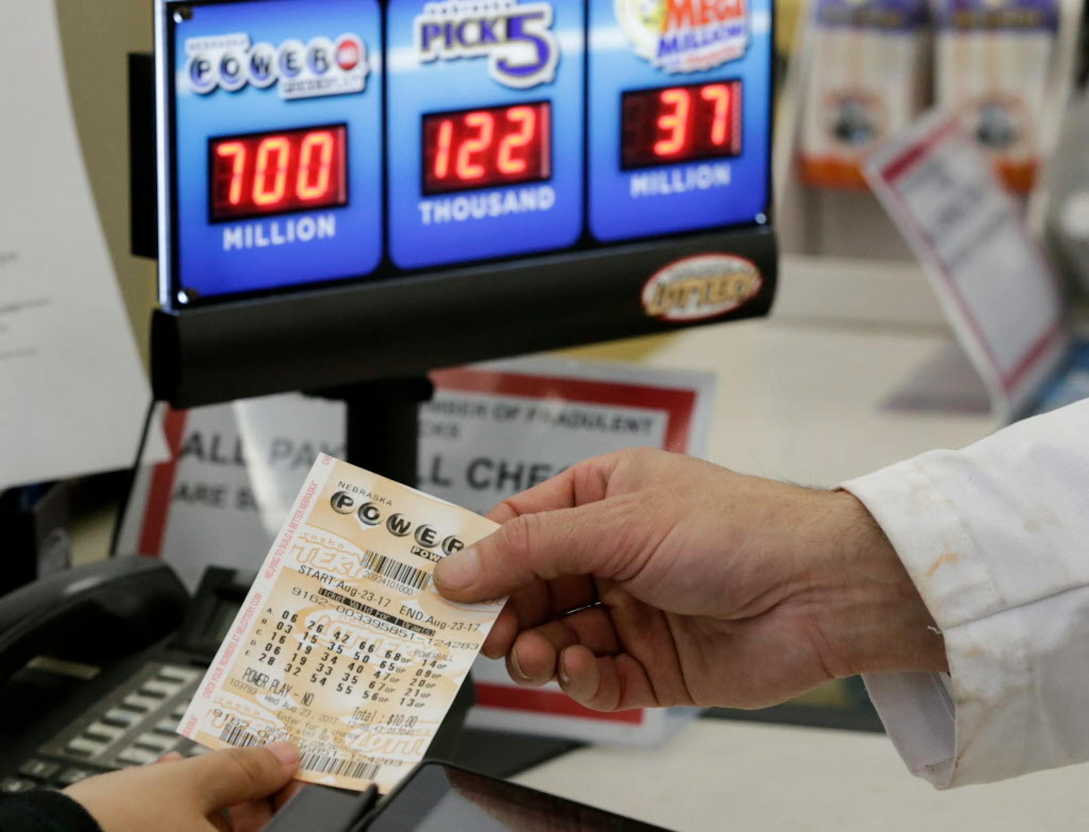 A customer is handed a Powerball ticket.