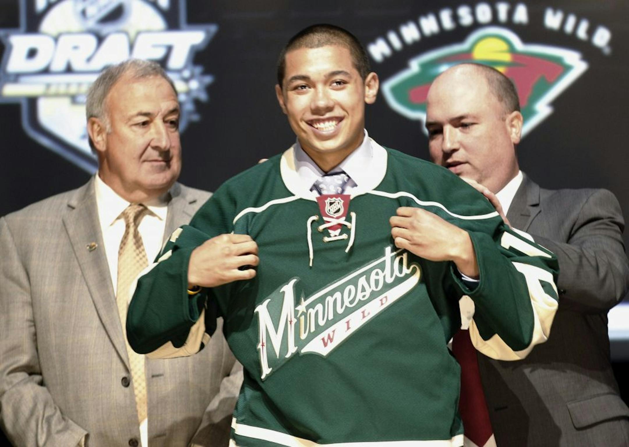 Matthew Dumba, center, a defenseman, smiles with officials from the Wild after being chosen seventh overall in the first round of the 2012 NHL draft.