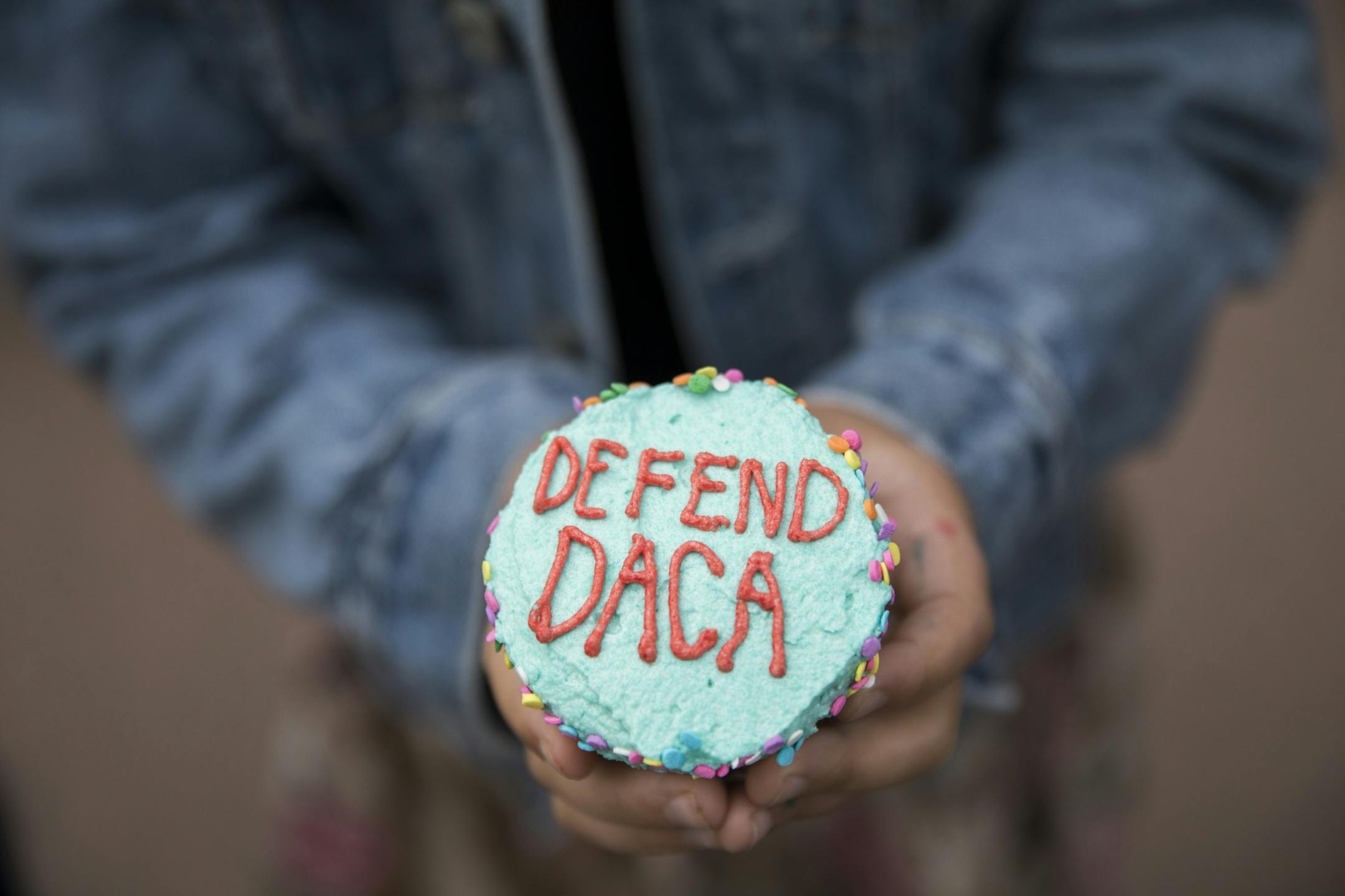 A girl handed out cupcakes at a protest after President Donald Trump announced his plans to rescind DACA on Tuesday, September 5, 2017, Minneapolis, Minn.