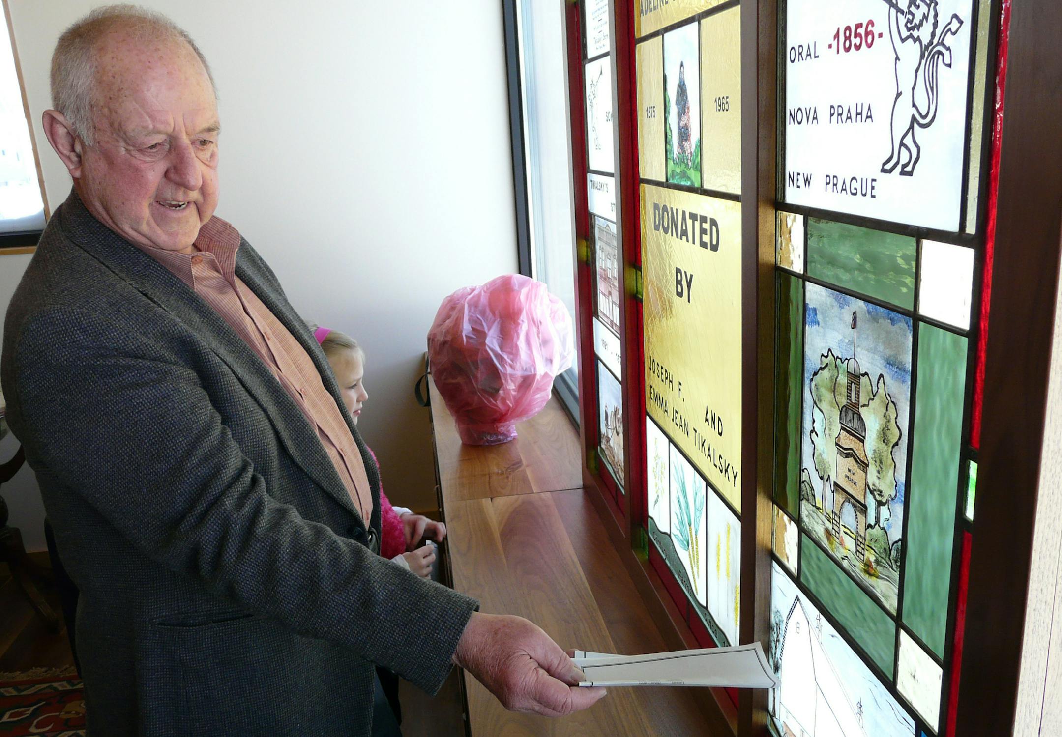 DAVID PETERSON ï david.a.peterson@startribune.com Ö 12/2008 Ö Joe Tikalsky, donor along with his wife Emma of the Mary J. Tikalsky Reading Room in the New Prague library, shows family members, including granddaughter Olivia, 9, some of the features of the commemorative stained glass window overlooking a park