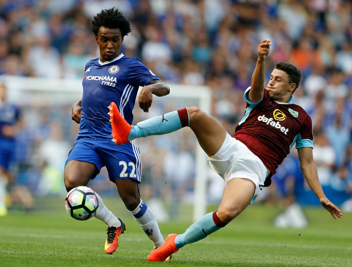 Chelsea's Willian, left, and Burnley's Matthew Lowton challenge for the ball during the English Premier League soccer match between Chelsea and Burnley at Stamford Bridge in London, Saturday, Aug. 27, 2016. (AP Photo/Frank Augstein)