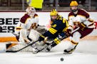 Gophers goalie Justen Close and defenseman Sam Rinzel battle against Michigan's Dylan Duke in Minnesota's most recent game, March 16, a loss in the Bi