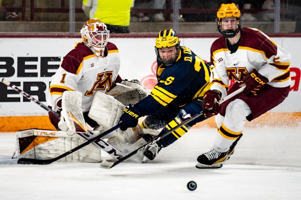 Gophers goalie Justen Close and defenseman Sam Rinzel battle against Michigan's Dylan Duke in Minnesota's most recent game, March 16, a loss in the Bi