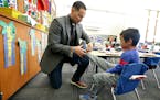Linwood Monroe Arts Plus School principal Bryan Bass tied the shoes of one of the students, Wednesday, December 21, 2016 in St. Paul, MN. ] (ELIZABETH