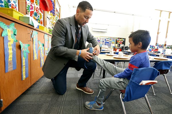 Linwood Monroe Arts Plus School principal Bryan Bass tied the shoes of one of the students, Wednesday, December 21, 2016 in St. Paul, MN. ] (ELIZABETH