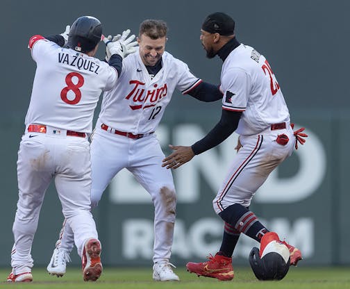 Minnesota Twins third baseman Kyle Farmer (12) reacts as catcher Christian Vazquez (8), left, and center fielder Byron Buxton (25) celebrate his walk off single in the tenth inning to defeat the Houston Astros 3-2 on Opening Day at Target Field in Minneapolis.