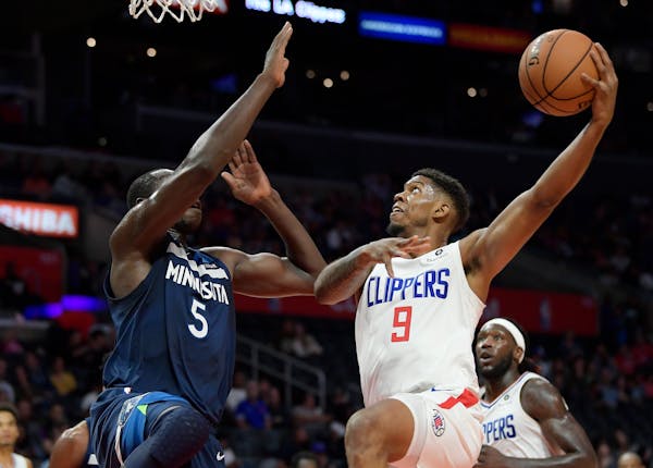 Los Angeles Clippers guard Tyrone Wallace, right, shoots as Timberwolves center Gorgui Dieng defends during the first half Wednesday night.