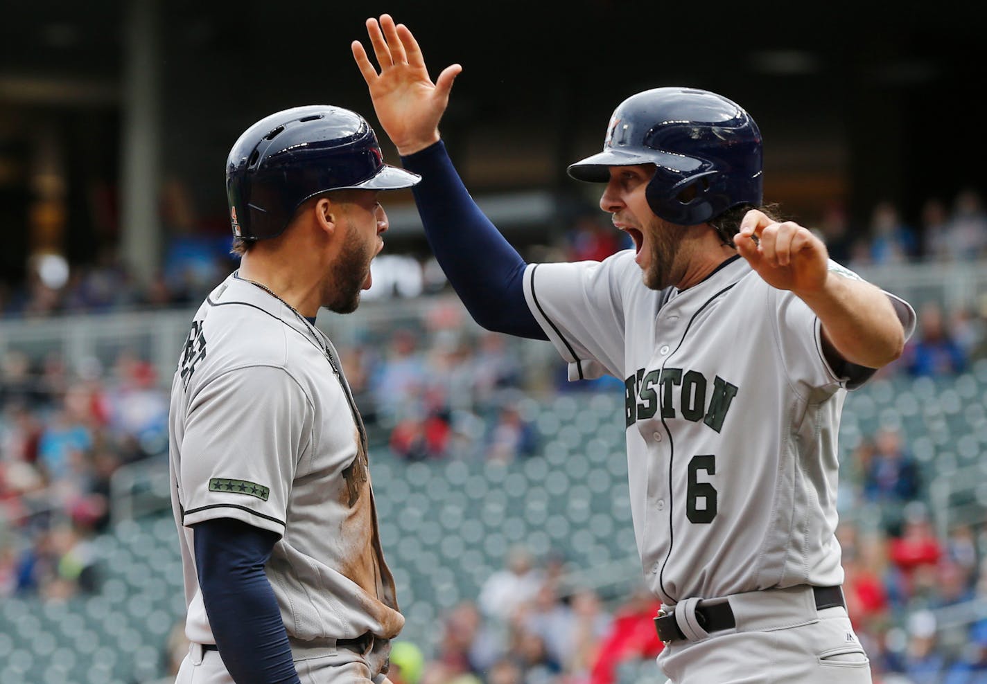 The Astros' George Springer, left, and Jake Marisnick celebrated as they score the tying and go-ahead runs against the Twins on a double by Josh Reddick in the eighth inning at Target Field on Monday.