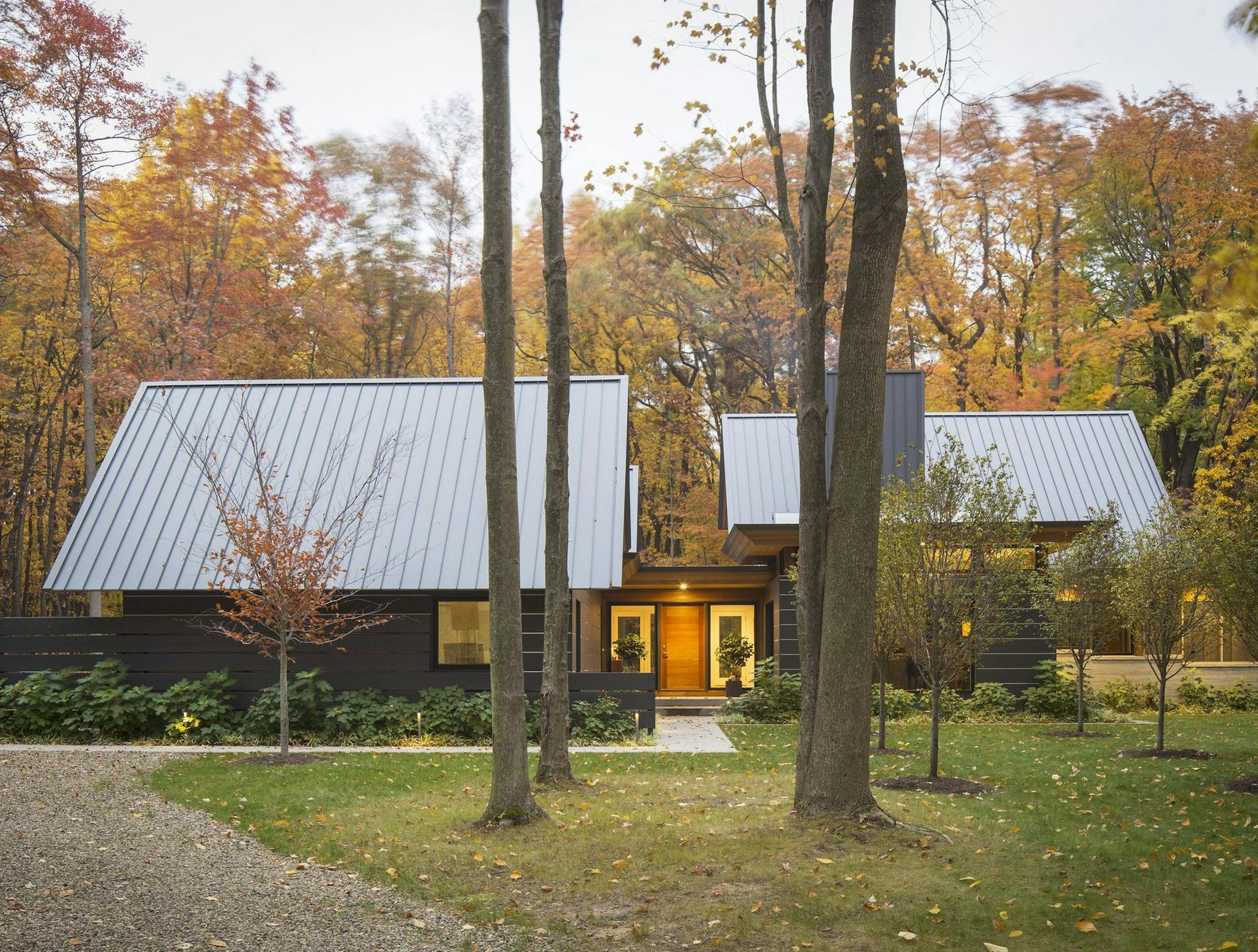 Wooded retreat is composed of two pavilions connected by the front entry, by Katherine Hillbrand, SALA Architects.