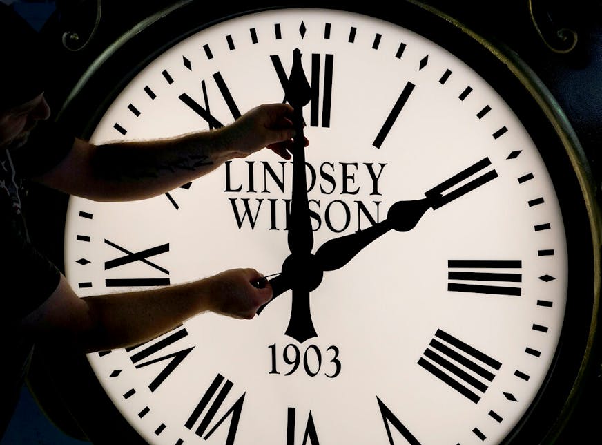 Dan LaMoore adjusts the hands on a Seth Thomas Post Clock at Electric Time Company, Friday, Oct. 23, 2020, in Medfield, Mass. Daylight saving time ends at 2 a.m. local time Sunday, Nov. 1, 2020, when clocks are set back one hour.