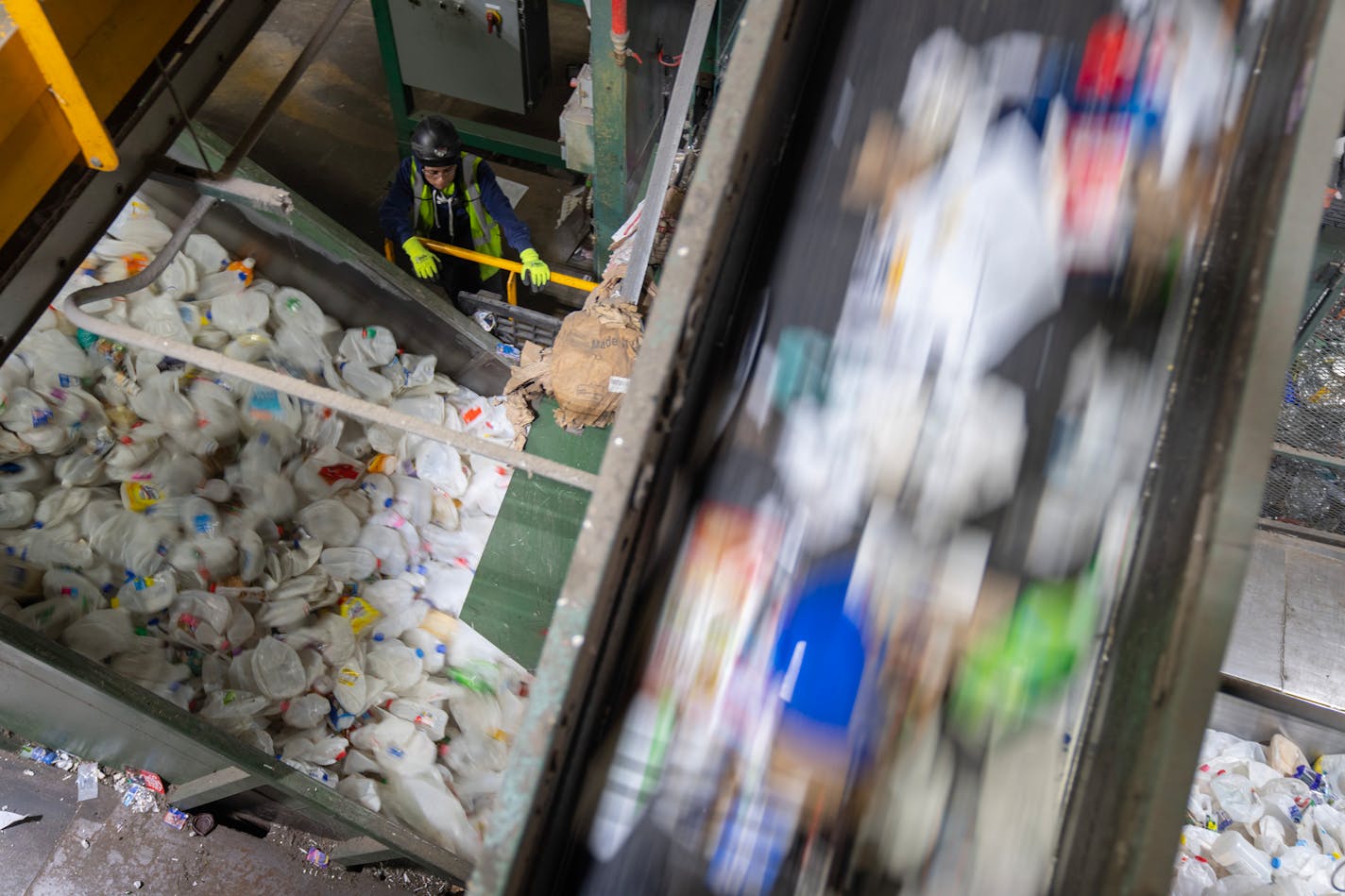 Recyclables from the tipping floor are moved along a conveyor belt to be sorted above another belt transports HDPE #2 recyclables, which are almost exclusively milk jugs, to a baler Tuesday, Jan. 09, 2024, at Eureka Recycling in Minneapolis, Minn. ]