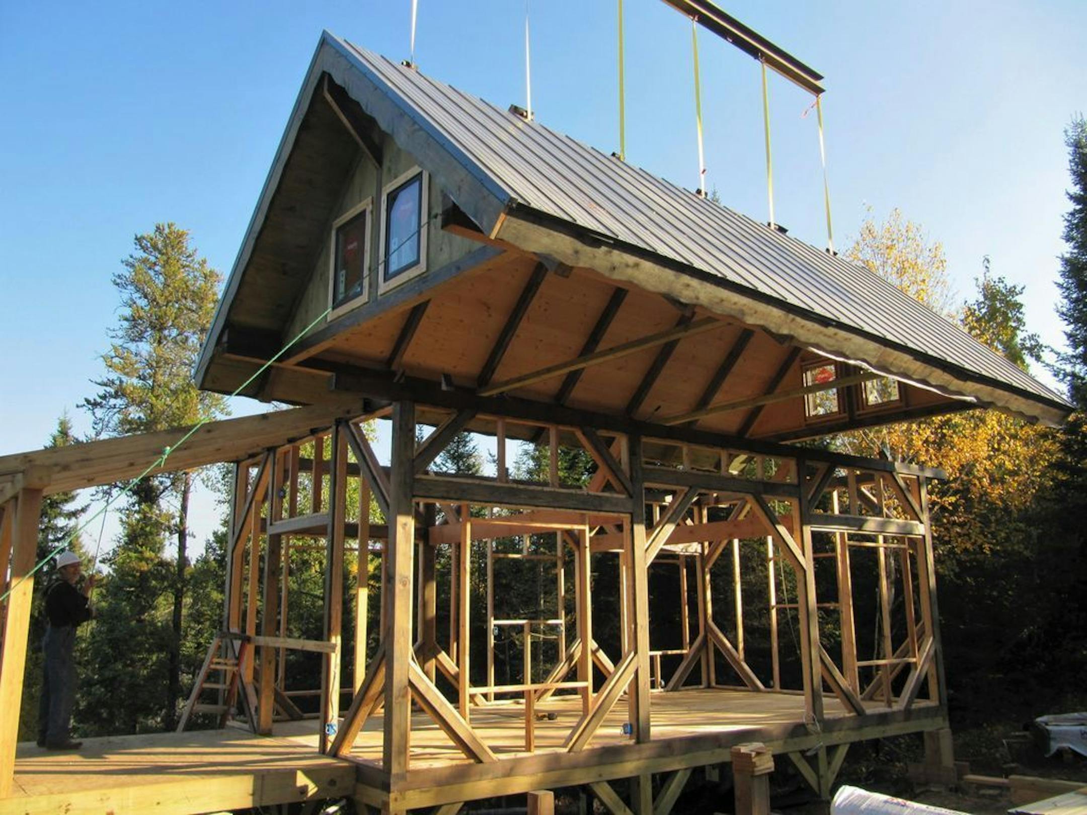 The timber-frame roof structure was lifted onto the main-floor frame with a crane.