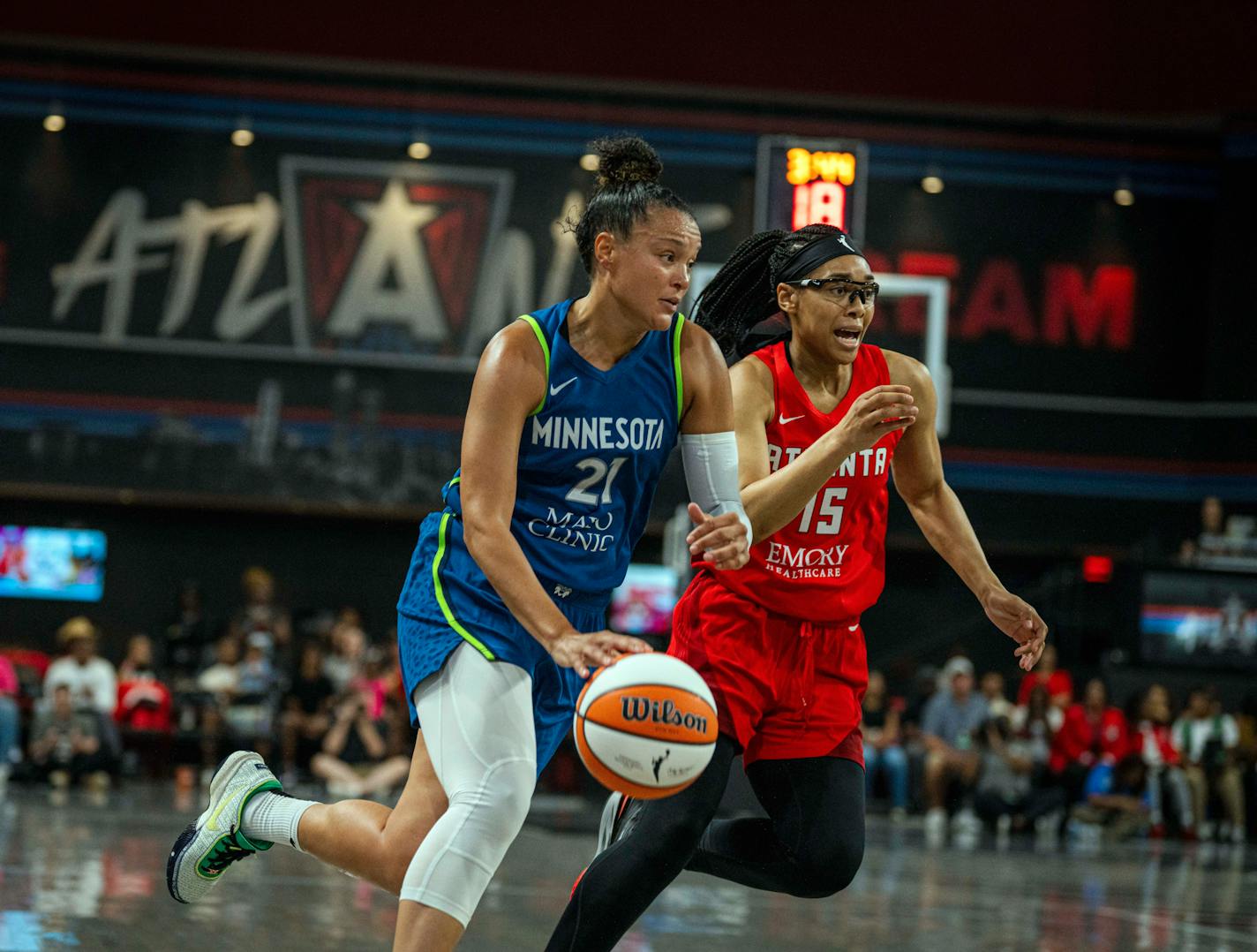 Minnesota Lynx Kayla McBride (21) dribbles past Atlanta Dream guard Allisha Gray (15) during a WNBA basketball game Tuesday, July 18, 2023, in College Park, Ga. (Matthew Pearson/WABE via AP)