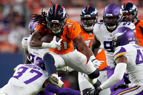 Broncos running back JaQuan Hardy (41) is wrapped up by Vikings safety Mike Brown (37) during the first half of Saturday’s preseason game in Denver.