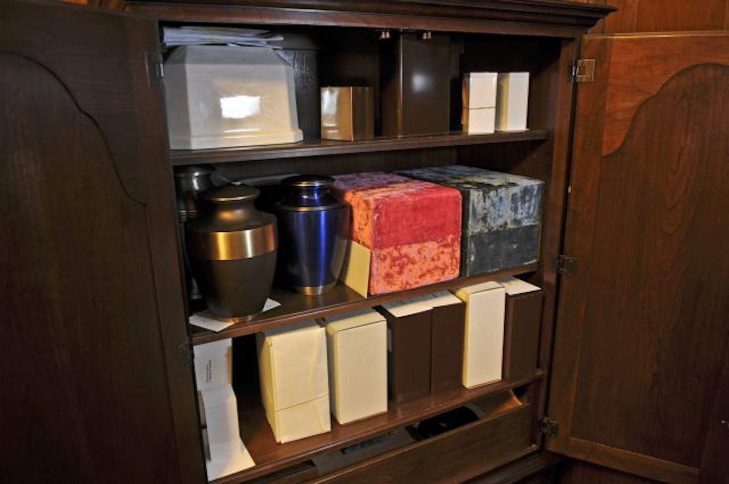 This cabinet at Gill Brothers Funeral and Cremation Services holds about 30 containers waiting to be claimed, including a box of ashes from a cremation in 1964.