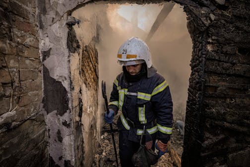 A Ukrainian firefighter stands in the ruins of a house destroyed by bombing in Kyiv, Ukraine, Wednesday, March 23, 2022. The Kyiv city administration says Russian forces shelled the Ukrainian capital overnight and early Wednesday morning, in the districts of Sviatoshynskyi and Shevchenkivskyi, damaging buildings. (AP Photo/Vadim Ghirda)