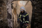 A Ukrainian firefighter stands in the ruins of a house destroyed by bombing in Kyiv, Ukraine, Wednesday, March 23, 2022. The Kyiv city administration 