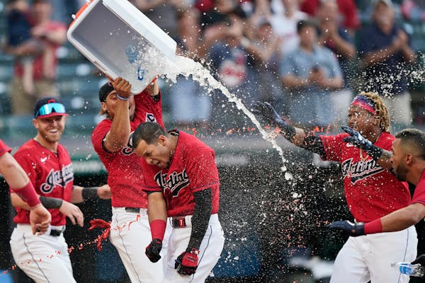 Cleveland teammates douse Cesar Hernandez, center, after he hit the winning two-run home run in the 10th inning against the Twins