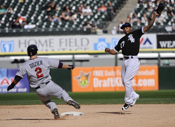Chicago White Sox's Leury Garcia (27) reaches for the ball as Minnesota Twins' Brian Dozier (2) slides into second base.