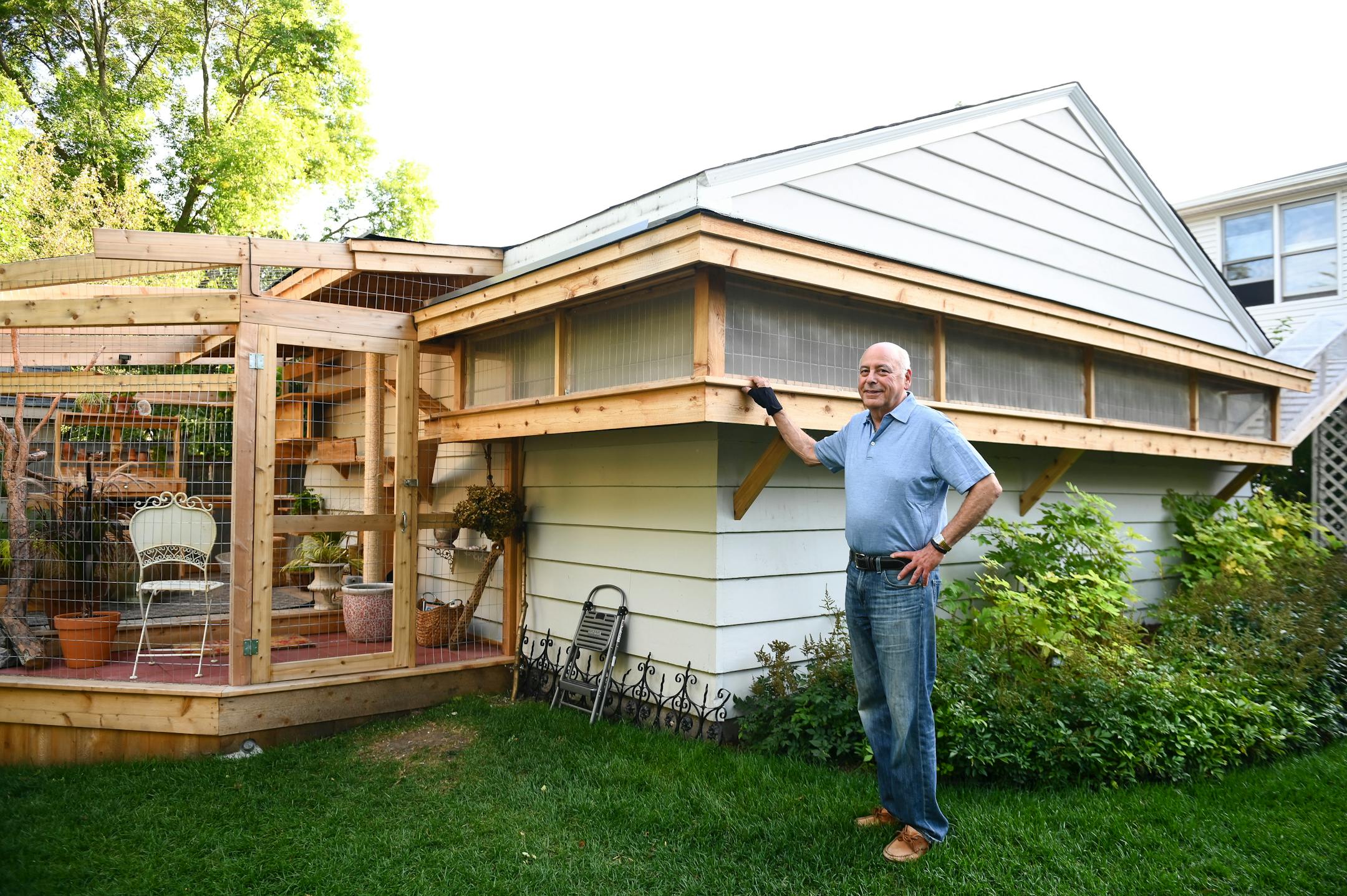 David Baum stands outside the "catio" added to his home, which he owns with his wife Suzy Kronfeld.